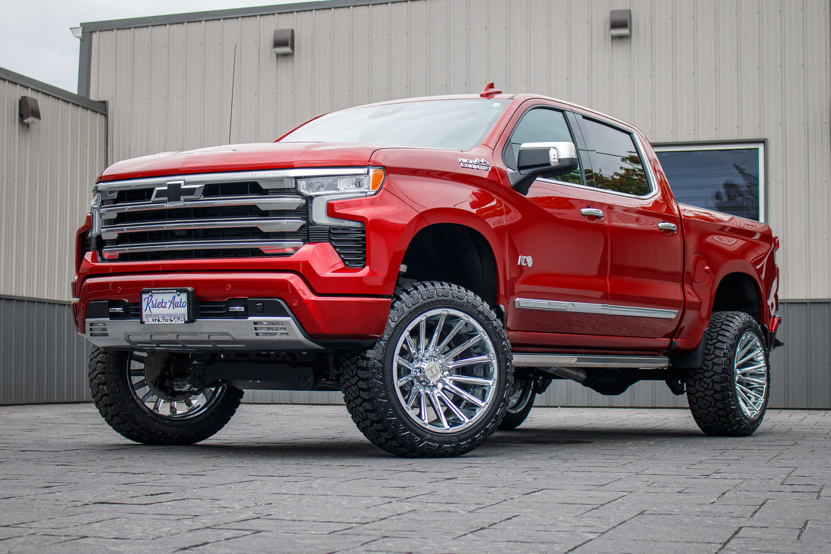 2023 Chevrolet Silverado 1500 High Country with a 6" Rough Country suspension kit, 22x12 Hostile Typhoon wheels, and 35" Fury Country Hunter R/T tires.